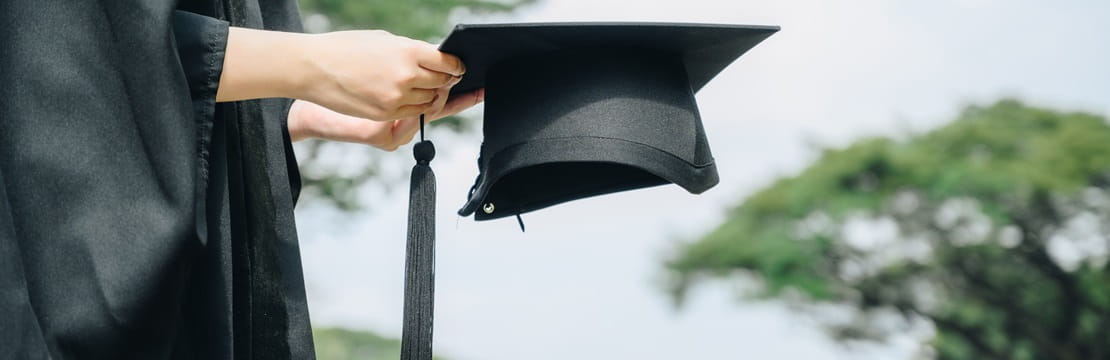 Woman holding graduation cap.
